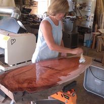 John's wife, Mary, applies finish to a project in their workshop