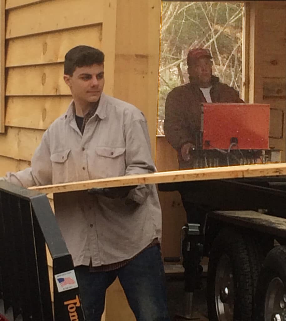 Here's John III taking boards off the TimberKing 2200 mill while his grandfather operates the mill.