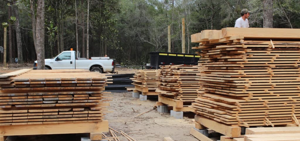 Adam makes a big lumber harvest, every board sawn and salvaged from trees felled to make way for new construction. These boards, felled and sawn on the customer's property, will be used to build the customer's home.