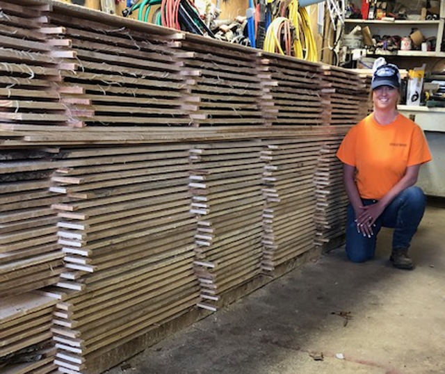 Here's Brianna with a stack of boards the couple sawed recently.